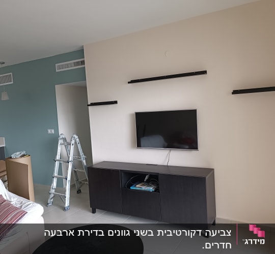 סולם מתכת עומד ליד קיר צבוע בשני צבעים